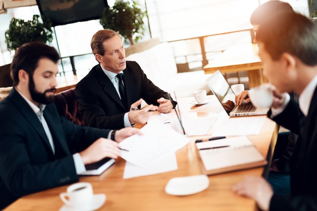 Hombres de negocios en la mesa discuten problemas de negocios