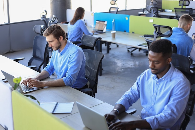 Hombres de negocios modernos que analizan los datos del mercado de valores mientras trabajan en la oficina.