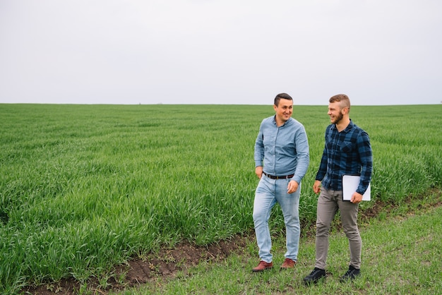 hombres de negocios de pie en un campo de trigo