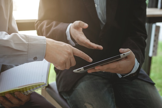 Hombres de negocios que se encuentran trabajando con financiero y una tableta.