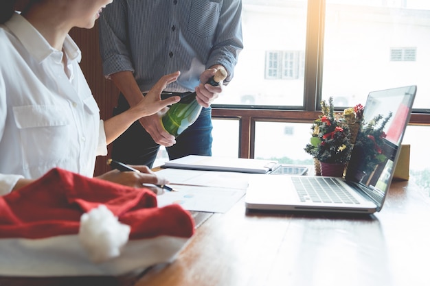 Hombres de negocios que llevan el sombrero de Papá Noel que celebra 2019 regalos de Navidad del Año Nuevo en la oficina