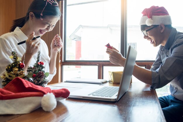 Hombres de negocios que llevan el sombrero de Papá Noel que celebra 2019 regalos de Navidad del Año Nuevo en la oficina