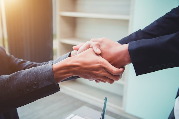 Los hombres de negocios que sacuden las manos asocian al líder de equipo acertado y a la reunión de negocios