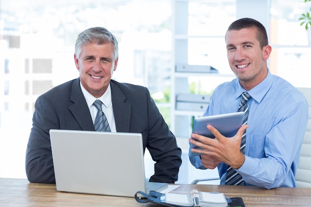 Hombres de negocios que trabajan junto con la computadora portátil y la tableta