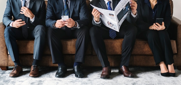 Foto hombres de negocios que trabajan en el teléfono y leyendo el periódico