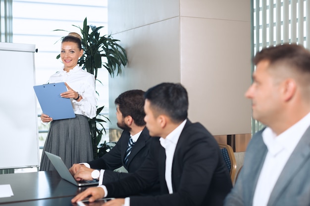 Hombres de negocios reunidos alrededor de una mesa de juntas discutiendo la estrategia