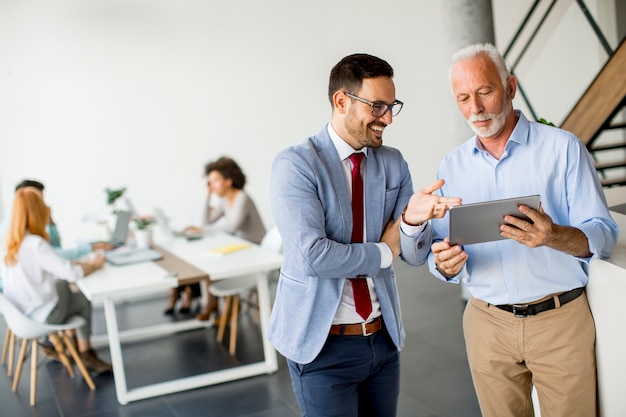 Hombres de negocios con tableta digital en la oficina