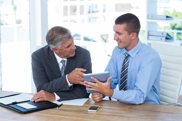 Hombres de negocios trabajando juntos con tableta