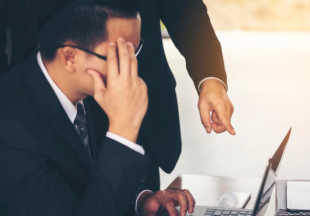 Foto hombres de negocios usando computadora portátil en el escritorio en la oficina