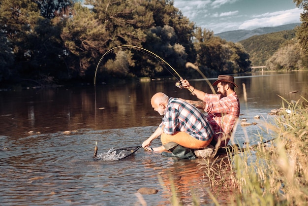 Hombres pescadores amigos y truchas trofeo padre e hijo pescando generaciones hombres pescando en la captura del río