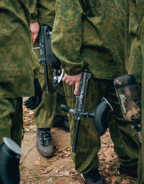 Hombres con pistolas jugando al paintball. Al aire libre