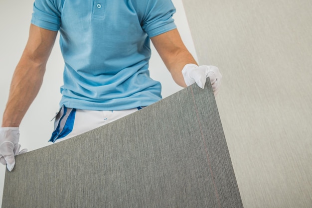 Hombres preparando nuevo papel tapiz de vinilo para Wallcover