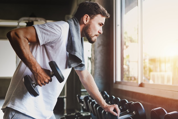 Los hombres del primer que sostienen sano entrenamiento de la pesa de gimnasia y construyen el cuerpo en la aptitud del gimnasio