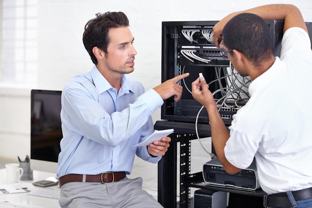 Los hombres profesionales de ingeniería y tecnología de la información de hardware reparan la placa base en la sala de servidores Manufactura o mantenimiento de servicio o soporte técnico y compañeros de trabajo masculinos en la oficina