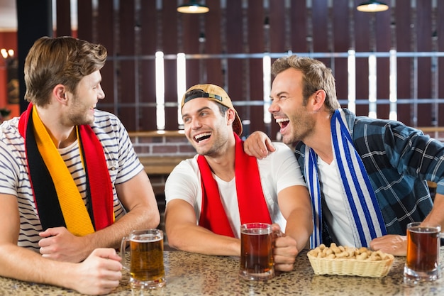 Hombres riendo con cervezas en las manos