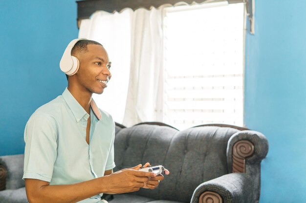 Hombres sonrientes jugando videojuegos en la televisión en casa Joven negro con joysticks juego