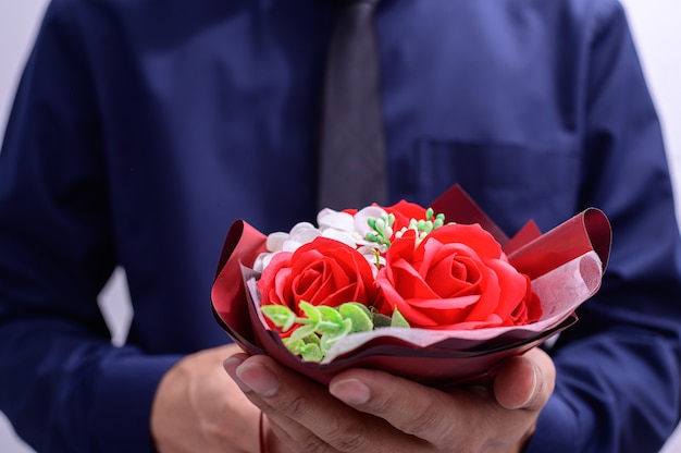 Los hombres sostienen un ramo de rosas en el día de san valentín