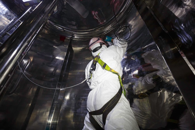 Los hombres suben las escaleras hacia el proceso de inspección de los trabajadores del tanque espacio confinado de seguridad química