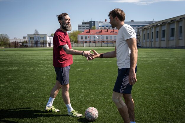 Hombres de tiro completo en el campo de fútbol