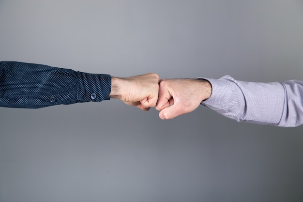 Los hombres tocan con los puños sobre la superficie gris.