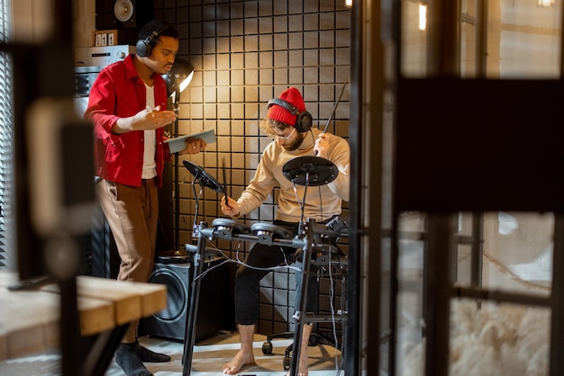 Hombres tocando tambores eléctricos en casa sstudio