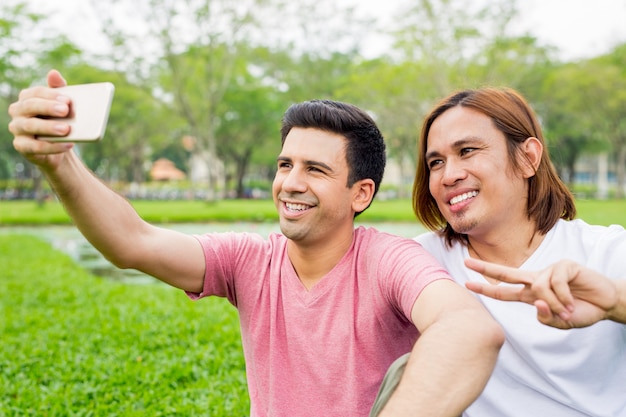 Hombres tomando Selfie y mostrando victoria firman en el parque