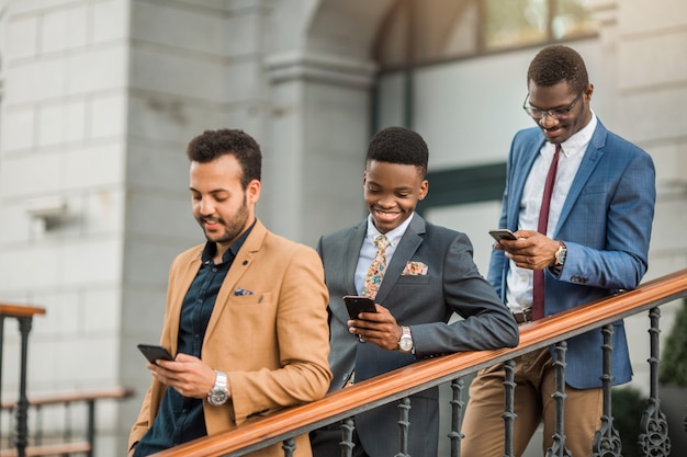 hombres de traje con teléfonos en la mano