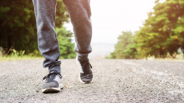 Los hombres usan zapatillas y trotar en un jardín.