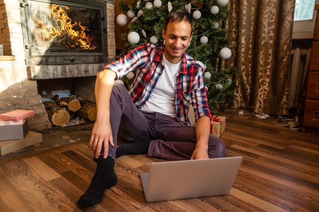 Hombres usando laptop en una vieja casa de madera durante las vacaciones de Navidad