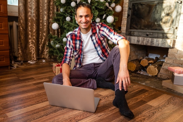 Hombres usando laptop en una vieja casa de madera durante las vacaciones de Navidad