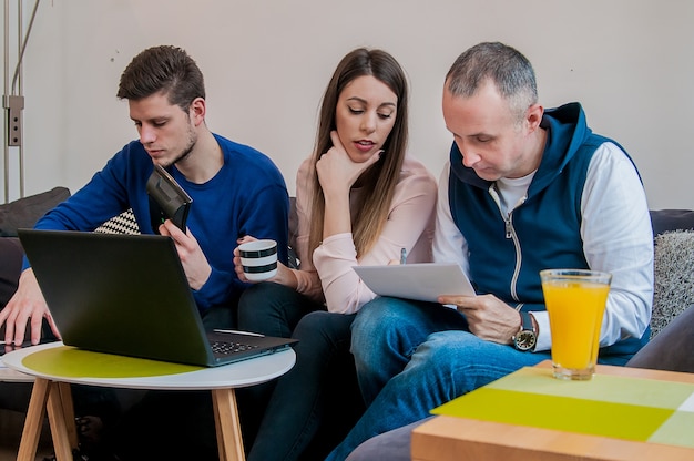 Home concepto de trabajo. Grupo de estudiantes étnicos multi étnicos que se preparan para los exámenes en el interior casero. Grupo de amigos que trabajan en una computadora en el país