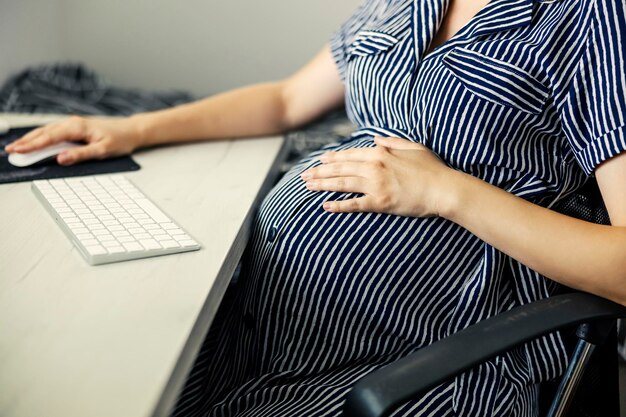 Foto home office e mulher de negócios grávida vestindo listras vestido de dona de casa de negócios