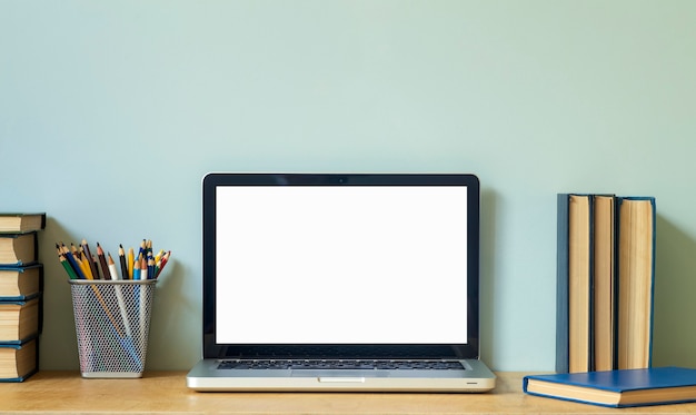 Home-Office-Schreibtisch-Tabellenhintergrund. Leerer Laptop-Bildschirm-PC auf dem Holztisch mit Büchern für Arbeit oder Studium. Foto in hoher Qualität