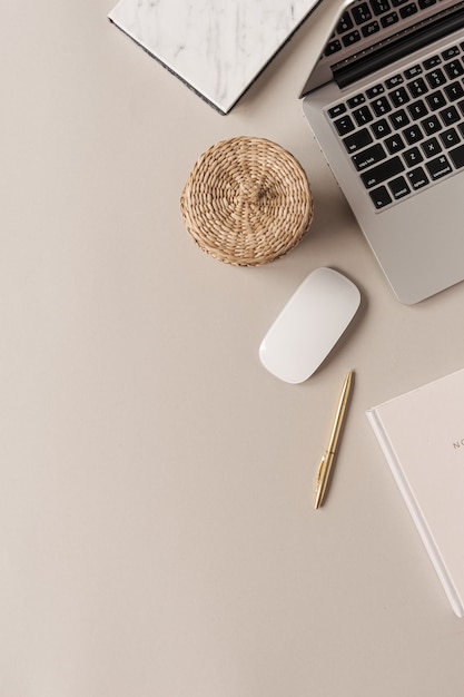 Home-Office-Schreibtischarbeitsbereich mit Laptop, Strohschatulle auf neutralem Hintergrund. Flach liegen