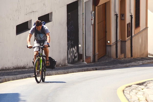 Homem a andar de bicicleta na calçada