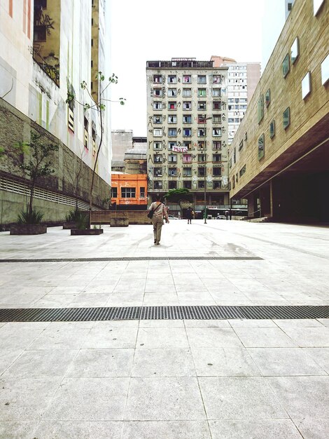 Foto homem a caminhar na rua da cidade