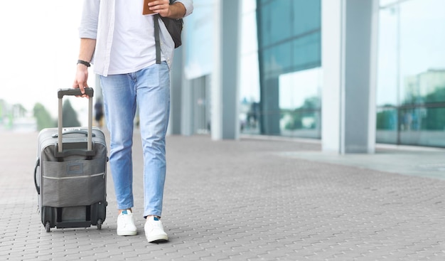 Homem a caminhar para o aeroporto com bagagem a bordo