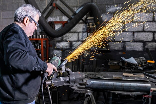 Homem a cortar metal com uma serra circular numa fábrica