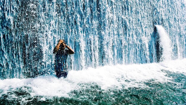 Homem a desfrutar de uma cachoeira