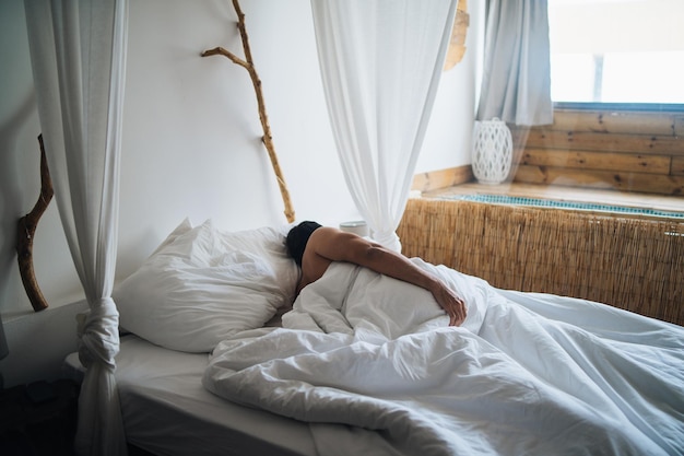 Homem a dormir na cama.