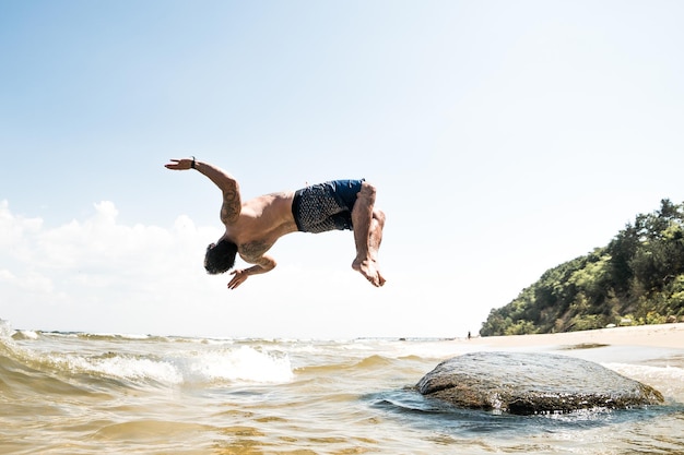 Homem a mergulhar no mar contra o céu