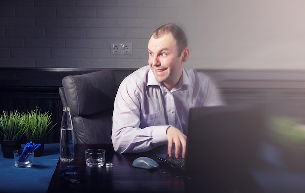 Homem à mesa e trabalhando no laptop