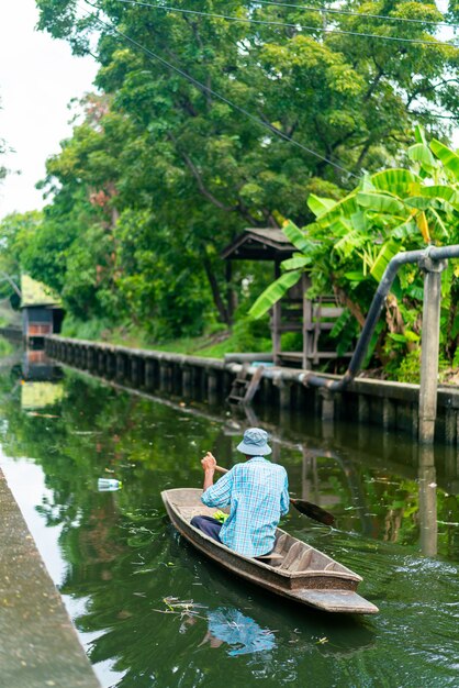 Homem a remar barco no pequeno canal