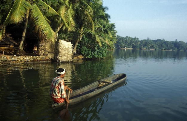 Homem a remar um barco no lago contra o céu