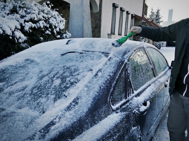 Homem a remover a neve do carro