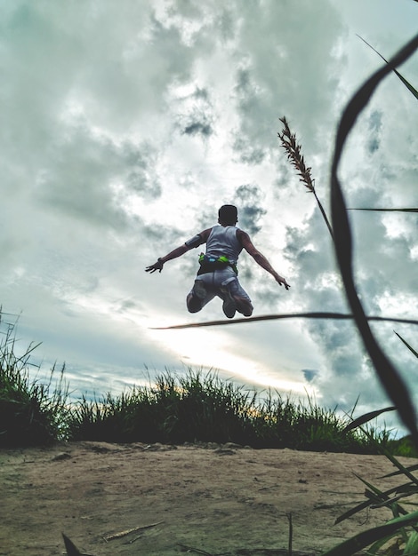 Foto homem a saltar contra o céu