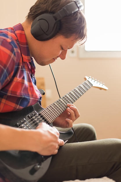 Homem a tocar guitarra em casa