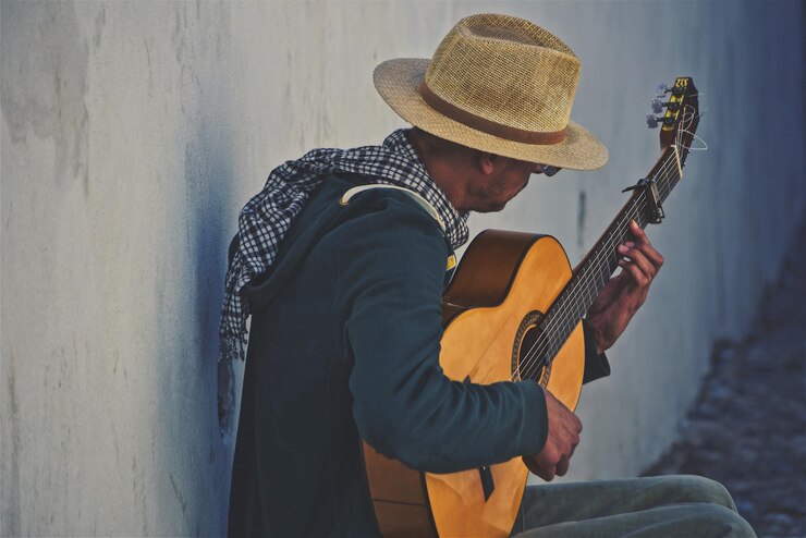 Foto homem a tocar guitarra na parede