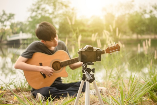 Homem a tocar guitarra no campo