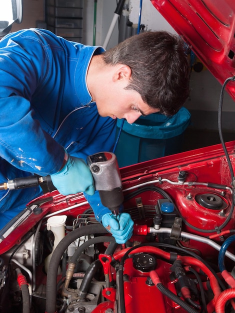 Foto homem a trabalhar num carro na garagem.